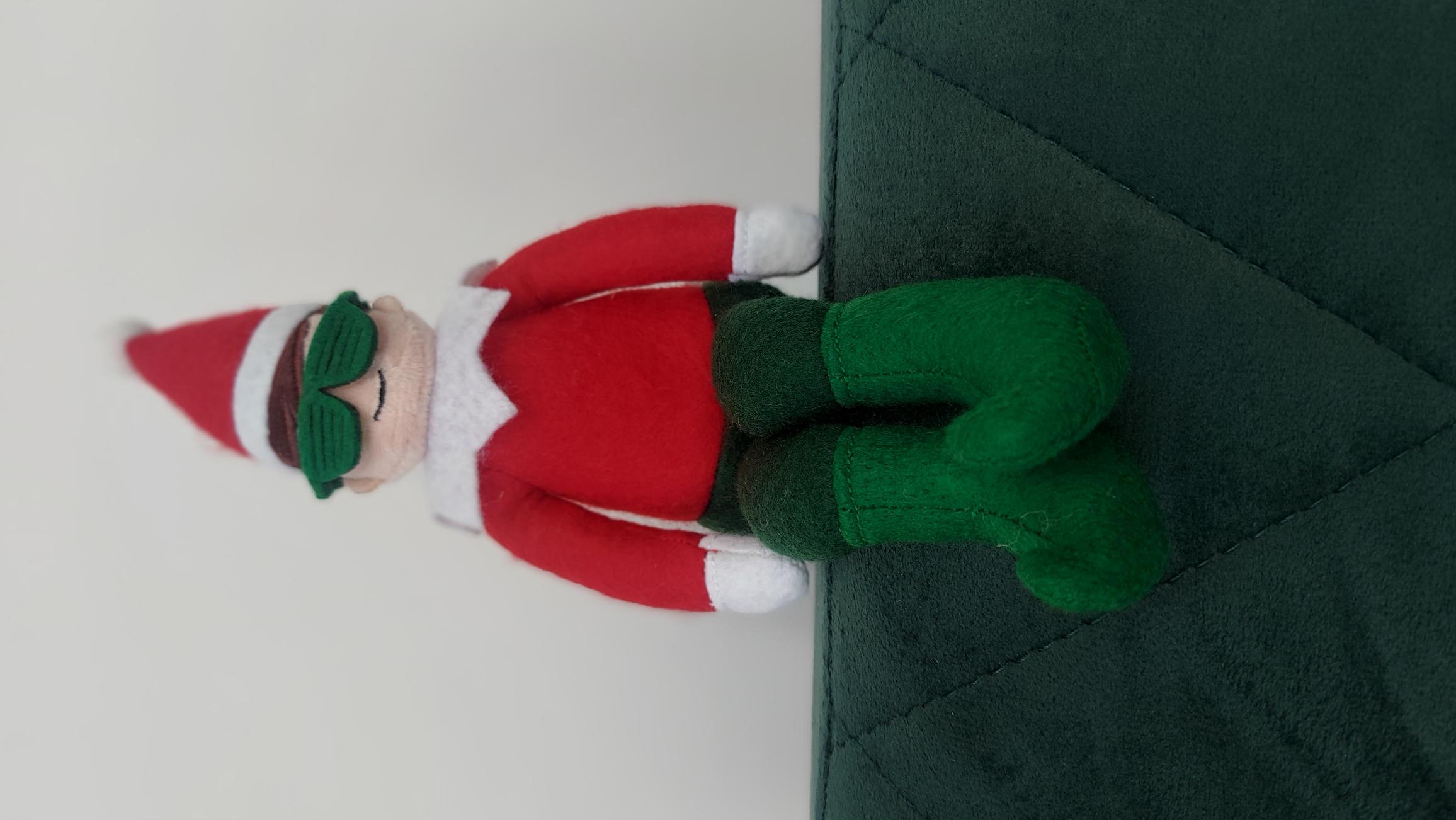 Official Cheeky Elves Jingles Doll sitting on a sofa
